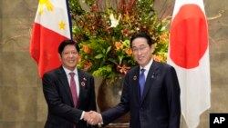 Perdana Menteri Jepang Fumio Kishida dan Presiden Filipina Ferdinand Marcos bersalaman sebelum pertemuan bilateral di Tokyo, 17 Desember 2023. (Foto: Franck Robinchon/Pool Photo via AP)