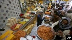 People buy traditional sweets in preparation for the upcoming Eid al-Fitr celebrations, at a shop in Peshawar, Pakistan, April 20, 2023. Eid al-Fitr marks the end of the Islamic holy month of Ramadan.