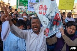 Umat Muslim memegang foto Mirza Ghulam Ahmad Qadiani saat mereka melakukan protes terhadap Ketua Mahkamah Agung Qazi Faez Isa, di Peshawar pada 23 Februari 2024. (Abdul MAJEED / AFP)