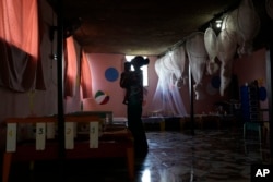FILE - A health worker holds a toddler at the Fontaine Hospital Center that treats malnourished children in the Cite Soleil area of Port-au-Prince, Haiti, May 29, 2023.