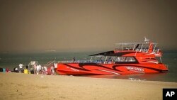 Tourists stand on a beach after being evacuated during a forest fire on the island of Rhodes, Greece, July 22, 2023. The blaze burned on the Greek island of Rhodes for a fifth day.