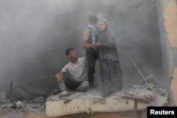 Warga Palestina di lokasi serangan Israel terhadap sebuah rumah, di tengah konflik Israel-Hamas, di Deir Al-Balah, di Jalur Gaza tengah. (Foto: Reuters)