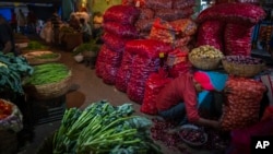 FILE - A vendor sorts onions in a wholesale vegetable market in Guwahati, India, March 14, 2023. A World Bank economic report says India is among the countries showing sustained economic growth.