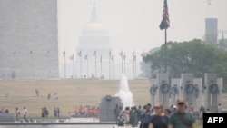 游客在被烟雾笼罩的首都华盛顿游玩。（2023年6月7日）