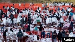 지난 20일, 미국 국경 마을 텍사스주 이글패스의 야외 처리센터에서 밤을 지새운 중남미 이주자들이 미 국경순찰대가 제공한 담요를 두르고 차례를 기다리고 있다. (자료 사진)