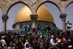 FILE - Palestinians hold the Palestinian national flag and the flag of the Hamas militant group during a protest by the Dome of Rock at the Al-Aqsa Mosque compound in the Old City of Jerusalem on April 7, 2023. (AP Photo/Mahmoud Illean)