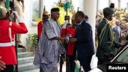 Senegal's President Macky Sall, right, is received by Nigerian Minister of Foreign Affairs Yusuf Tuggar in Abuja, Nigeria, Feb. 24, 2024. Leaders of the Economic Community of West African States met to address a political crisis in the coup-hit region.