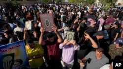 Supporters of Shiite Muslim leader Muqtada al-Sadr step on an LGBTQ+ rainbow flag in front of the Swedish Embassy in Baghdad in response to the burning of a Quran in Sweden, June. 30, 2023.