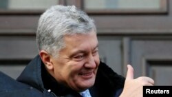 FILE - Ukrainian former President Petro Poroshenko gives a thumbs-up as he greets supporters after a court hearing in Kyiv, Ukraine, Jan. 19, 2022. 