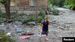 A woman speaks on the phone outside a multistory residential building damaged in recent shelling in the course of Russia-Ukraine conflict in Donetsk, Russian-controlled Ukraine, July 25, 2023.