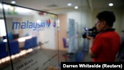 Seorang jurnalis sedang mengambil gambar loket tiket Malaysia Airlines di Jakarta 18 Juli 2014, dalam ilustrasi. Draft Revisi RUU Penyiaran terus mendapat penolakan dari publik, termasuk pelaku industri film. (Foto: REUTERS/Darren Whiteside)