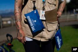 FILE - A mental health case manager carries pouches containing Narcan nasal spray kits in Santa Monica, Calif., Sept. 19, 2022.
