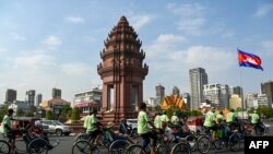 រូបឯកសារ៖ អ្នកធាក់ស៊ីក្លូ​កំពុង​ដឹក​ភ្ញៀវទេសចរកាត់វិមាន​ឯករាជ្យ​ នៅរាជធានីភ្នំពេញ កាលពីថ្ងៃទី១៦ ខែកុម្ភៈ ឆ្នាំ២០២៤។ 