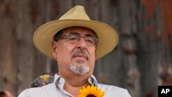 Seed Movement presidential candidate Bernardo Arevalo holds a sunflower during a campaign rally in Santa Maria de Jesus, Guatemala, July 16, 2023. 