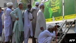 Afghan refugees wait at a National Database and Registration Authority van for data verification, at a police station in Karachi on Nov. 8, 2023. Pakistan says terror attacks in the country are up, and foreigners without legal status are linked to people fueling such incidents.