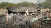 Army officers stand around blast damages after last night's fire that caused blasts at a military ammunition depot in N'Djamena, Chad, June 19, 2024. 
