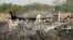 Army officers stand around blast damages after last night's fire that caused blasts at a military ammunition depot in N'Djamena, Chad, June 19, 2024. 