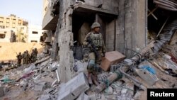 Izraelski vojnici stoje u ruševinama zgrade tokom kopnene invazije protiv palestinske militantne grupe Hamas, na severu Pojasa Gaze, 8. novembra 2023.