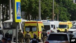 Anggota kepolisian Rusia dan sejumlah ambluans tampak berkumpul di dekat pusat penahanan di Rostov-on-Don, Rusia, pada 16 Juni 2024. (Foto: AP)