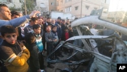 가자지구 라파에서 이스라엘군 공습으로 부서진 하마스 경찰차 주변에 6일 팔레스타인인들이 모여 있다.