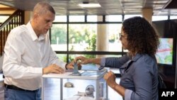 A voter puts her vote into the ballot box for the first round of France's general elections at a polling station in Remire-Montjoly town hall in the French overseas department of Guiana, June 29, 2024.