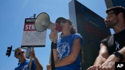 Justine Bateman, right, speaks outside Netflix during a Writers Guild rally as a strike by The Screen Actors Guild-American Federation of Television and Radio Artists is announced on July 13, 2023, in Los Angeles. 