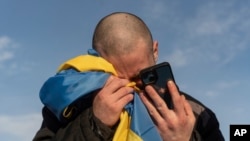 FILE - A recently swapped Ukrainian prisoner of war cries while calling his relatives after a prisoner exchange on the Ukraine-Russia border on Jan. 31, 2024. 