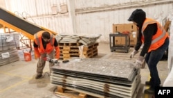 Workers dismantle solar panels to be recycled at the We Recycle Solar plant in Yuma, Arizona, Dec. 6, 2023.