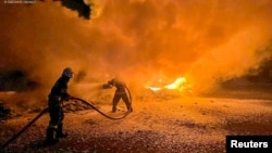 Vatrogasci gase pogođene kamione tokom ruskog napada drnovima na luku na Duvanu, u regionu Odese, Ukrajina, 26. septembra 2023.