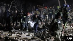 Ukrainian police officers and rescuers carry the body of a local resident killed in a Russian rocket attack in Kramatorsk, Donetsk region, on Feb. 17, 2024.