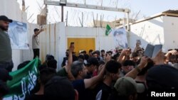 Para pengunjuk rasa Irak berkumpul di pintu masuk kedutaan Swedia di Baghdad, sehari setelah seorang pria merobek dan membakar salinan Al-qur'an di luar sebuah masjid di ibukota Swedia Stockholm, Kamis (29/6). 