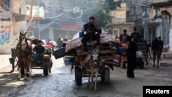 Palestinians transport belongings on animal-drawn carts, as they flee their houses after they were ordered by the Israeli army to evacuate the area, in Bureij in the central Gaza Strip, Dec. 26, 2023.