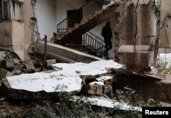 A Palestinian man walks in a damaged building after Israeli forces raided Jenin refugee camp in the Israeli-occupied West Bank, Nov. 19, 2023.