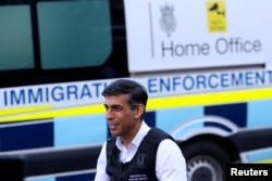 Perdana Menteri Inggris Rishi Sunak berdiri di samping mobil imigrasi di Kantor Polisi Wembley di barat laut London, Inggris, 15 Juni 2023. (REUTERS/Susannah Ireland/Pool)
