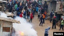 Des agents de police anti-émeute lancent des cartouches de gaz lacrymogène alors qu'ils participent à des manifestations anti-gouvernementales contre l'imposition de hausses d'impôts par le gouvernement dans la colonie de Kibera, Nairobi, Kenya 12 juillet 2023.