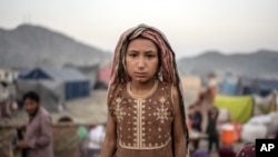 FILE — An Afghan refugee girl stands in a camp near the Torkham Pakistan-Afghanistan border in Torkham, Afghanistan, Nov. 4, 2023.
