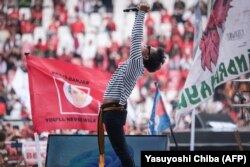 Seorang musisi tampil saat kampanye pemilihan calon presiden dan mantan Gubernur Jawa Tengah Ganjar Pranowo dan calon wakil presiden Mahfud MD di Stadion Gelora Bung Karno Jakarta, 3 Februari 2024. (Foto: Yasuyoshi Chiba/AFP)