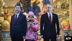 莫斯科街头一家旅游纪念品商店外树立的中俄领导人习近平和普京的纸板画像。（2023年11月15日）