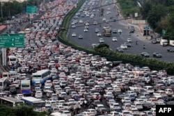 FILE - Vehicles are seen stuck in bumper-to-bumper traffic on the Delhi-Jaipur expressway in Gurgaon, India, April 25, 2023. (Photo by Vinay GUPTA / AFP)