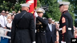 U.S. Marine Corps Gen. David Berger, left, hands the battle colors to Gen. Eric Smith during a relinquishment of office ceremony, at the Marine Barracks in Washington, July 10, 2023. 