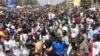 FILE - Civil society groups and political groups hold placards as they march calling on authorities respect the election date, in Dakar, on Feb. 17, 2024.