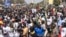 FILE - Civil society groups and political groups hold placards as they march calling on authorities respect the election date, in Dakar, on Feb. 17, 2024.