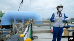 Tomohiko Mayuzumi, juru biacara Tokyo Electric Power Company Holdings, yang dikenal dengan sebutan TEPCO, berbicara dalam tur di PLTN Fukushima Daiichi di Futaba, Jepang, pada 14 Juli 2023. (Foto: AP/Hiro Komae)