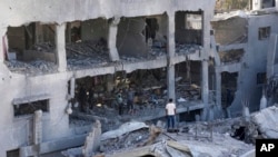 Palestinians inspect the rubble of a building destroyed in the Israeli bombardment of the Gaza Strip in Nusseirat refugee camp, central Gaza Strip, Nov. 23, 2023.