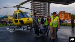 The body of a victim of a helicopter crash is carried out of a chopper in Kathmandu, Nepal, July 11, 2023. Five Mexican tourists and a Nepalese pilot have died when it crashed near Mount Everest in Nepal.