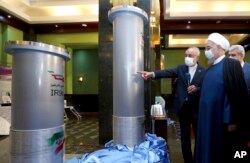 FILE - President Hassan Rouhani, 2nd right, listens to head of the Atomic Energy Organization of Iran Ali Akbar Salehi while visiting an exhibition of Iran's new nuclear achievements in Tehran, Iran, in this April 10, 2021, photo released by the office of the Iranian Presidency.