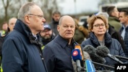 (L-R) Lower Saxony's State Premier Stephan Weil, German Chancellor Olaf Scholz and Lower Saxony's Interior Minister Daniela Behrens address journalists in Verden, western Germany, Dec. 31, 2023, during a visit to the flood stricken areas of Lower Saxony.