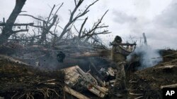 FILE - A Ukrainian soldier fires toward Russian positions at the front line near Avdiivka, an eastern city where fierce battles against Russian forces have been taking place, in the Donetsk region, Ukraine, on April 28, 2023. 