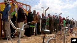 اردن میں شامی پناہ گزینوں کے لیے قائم ارزاق کیمپ میں پناہ گزین اپنے نام کا اندارج کرانے کے لیے قطار میں کھڑے ہیں۔