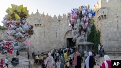 Umat Islam berjalan melewati Gerbang Damaskus di luar Kota Tua Yerusalem untuk mengikuti salat Iduladha di kompleks Masjid Al Aqsa, Rabu, 28 Juni 2023. (AP/Ohad Zwigenberg)